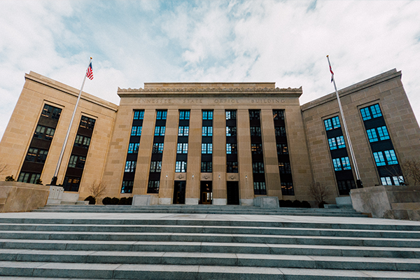 Slika stolpnice ameriske centralne banke z dvema ameriskima zastavama in stopnicami v ospredju 28072023